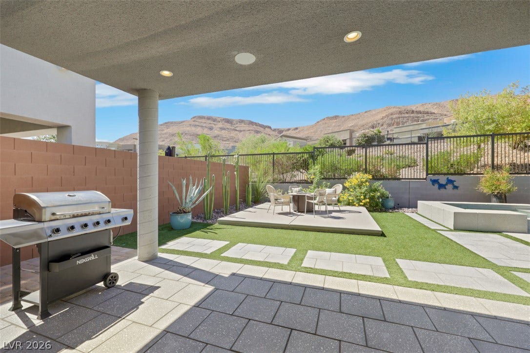 An inviting covered patio opens to a private backyard with mountain views.