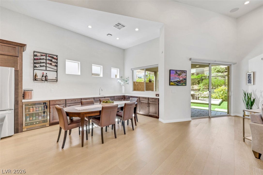 Soaring vaulted ceilings and rich wood floors frame this expansive dining area with glass sliders and amazing views.