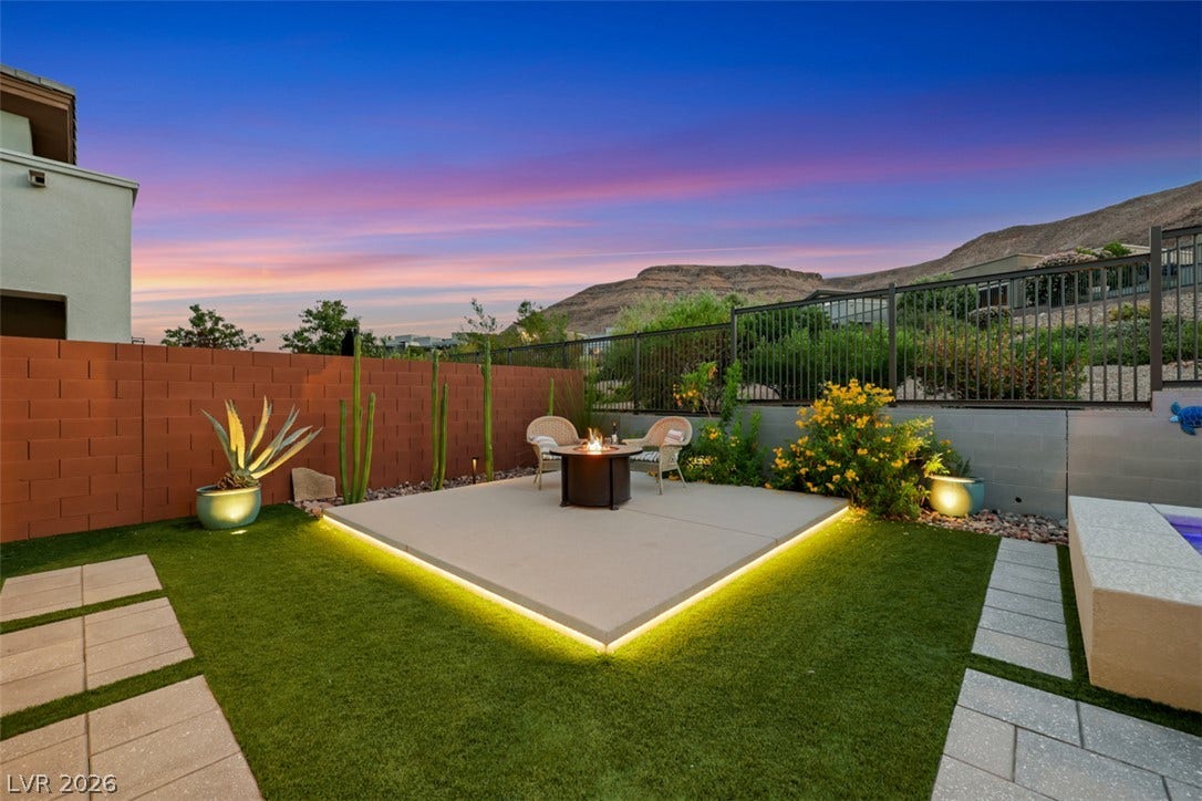 Customize concrete patio platform illuminated by LED strip lighting with a sophisticated gas fire feature.