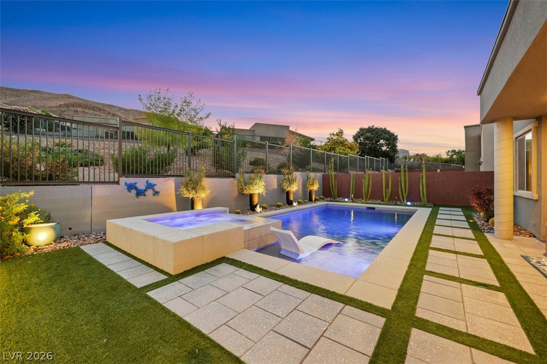 Lush turf and modern pavers surround a sparkling pool, the perfect spot for sunset gatherings!