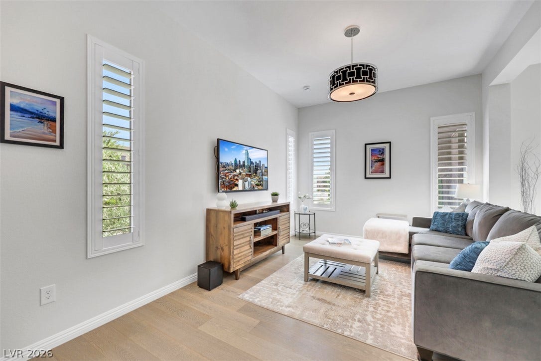 Crisp white walls define this bright living space featuring plantation shutters.