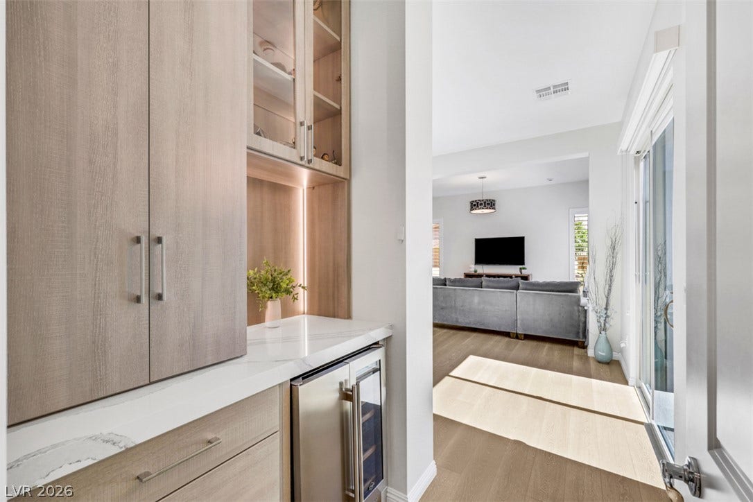 Custom cabinetry and a built-in beverage cooler line the hallway leading to the Multi-Gen.