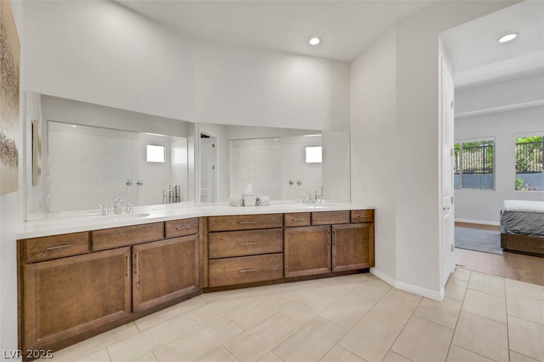 Clean lines and a spacious dual vanity highlight this modern, tile-floored bathroom.