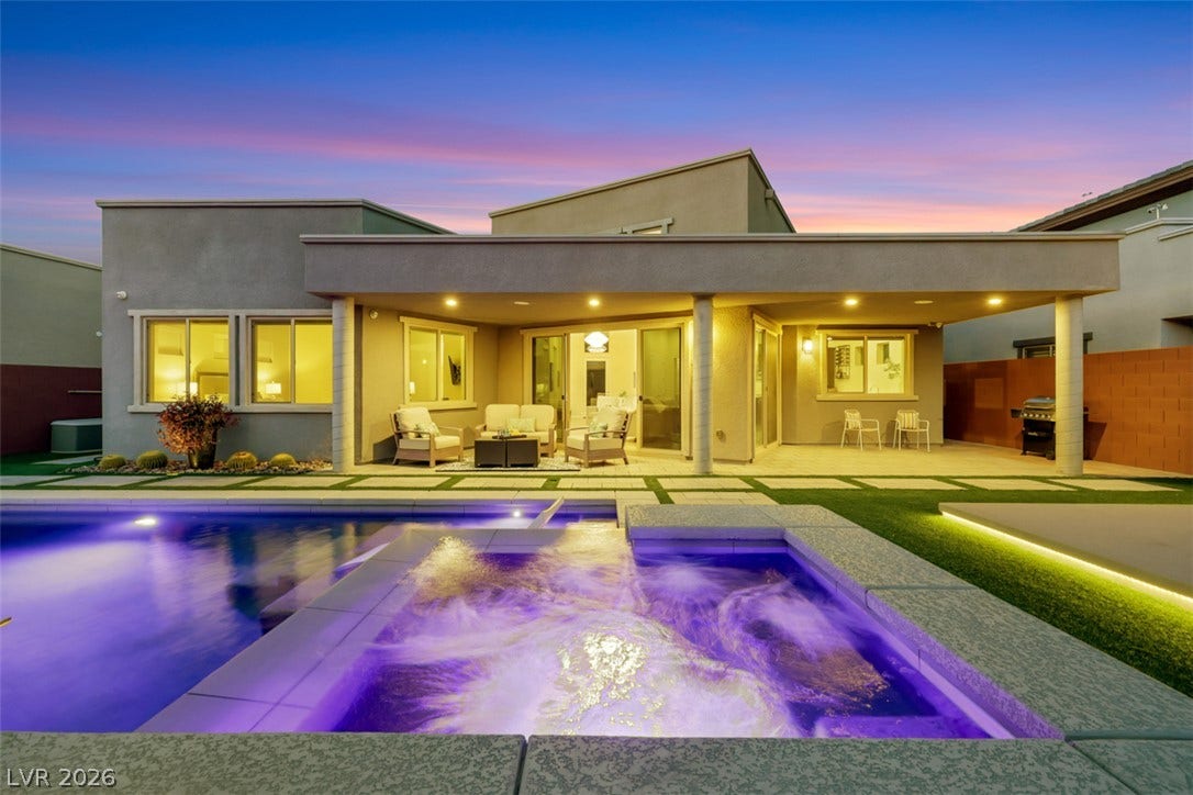 Resort inspired covered outdoor living overlooks pristine pool.