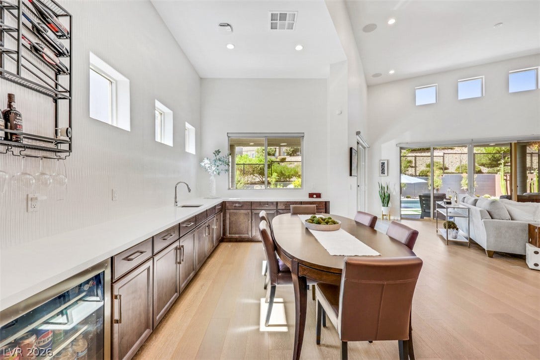 Gleaming hardwood floors and towering vaulted ceilings define this airy, open-concept dining space.