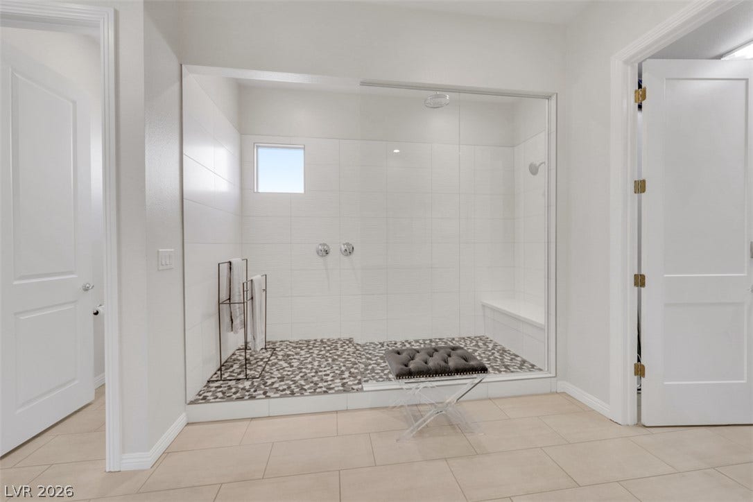 A spacious walk-in shower highlights  this Primary bathroom featuring a luxurious rain shower head and secondary shower head for a spa inspired experience.