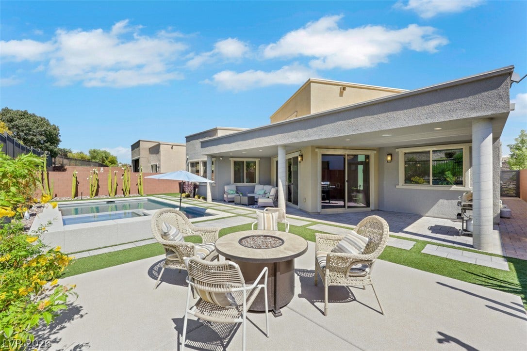 Elevated concrete step creates striking outdoor focal point, featuring a built-in fire pit for evening ambiance.
