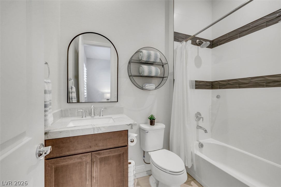 Tiled accents and a stone-topped vanity bring functional elegance to this cozy bathroom.