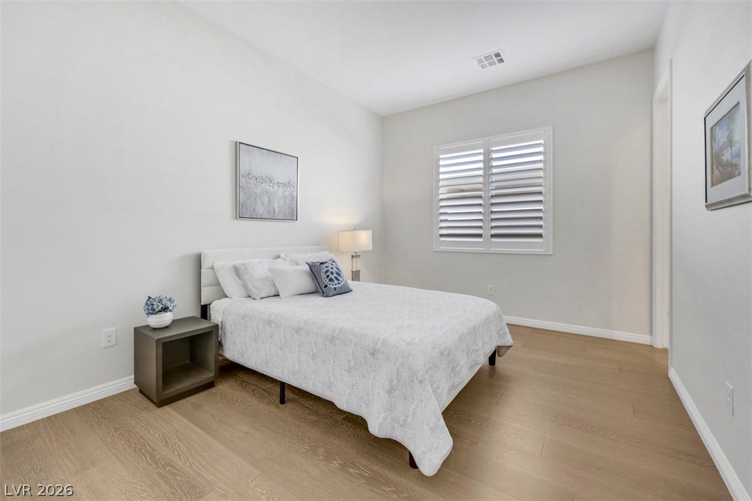 Plantation shutters, a private ensuite, and custom closet organizers elevate this serene guest suite.