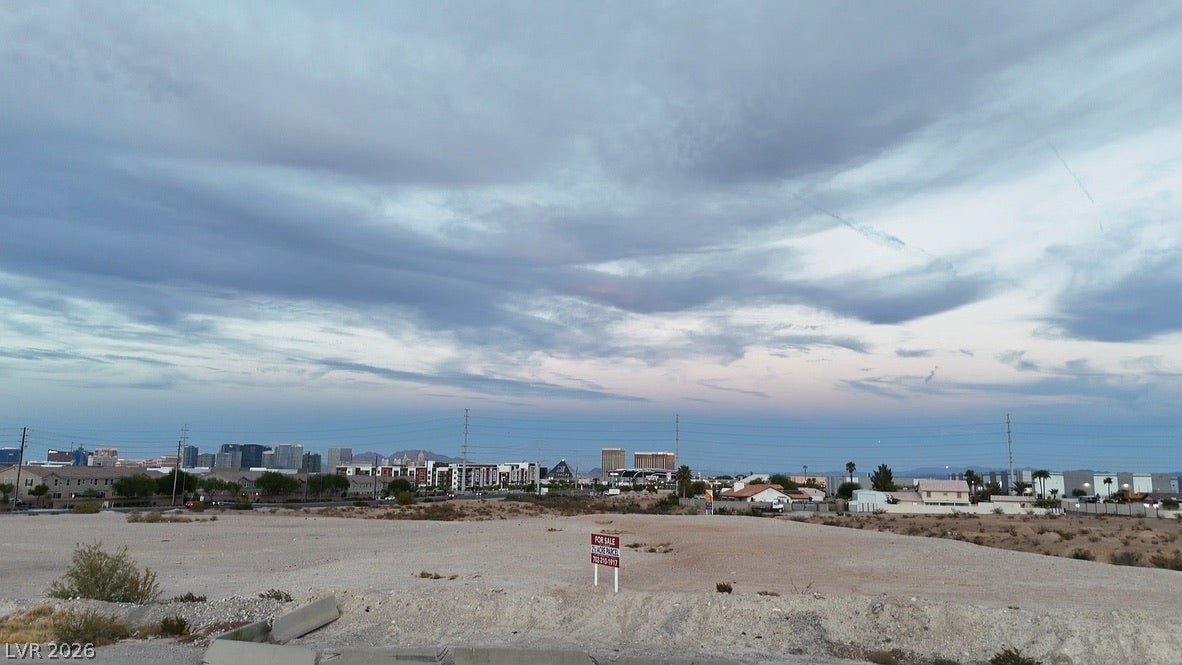 Lindell, Las Vegas, NV 89118 Distant city skyline views frame this expansive vacant lot under a dramatic evening sky.