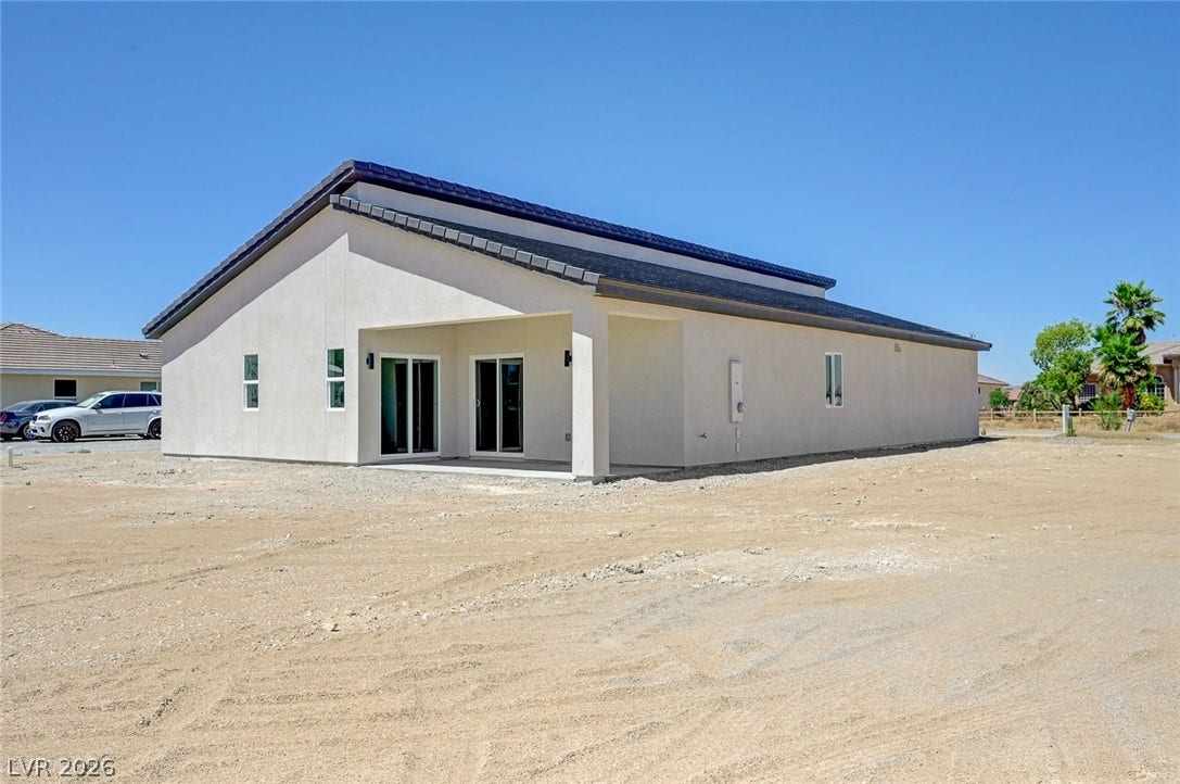 Clean lines and a spacious covered patio define the rear exterior of this modern home.