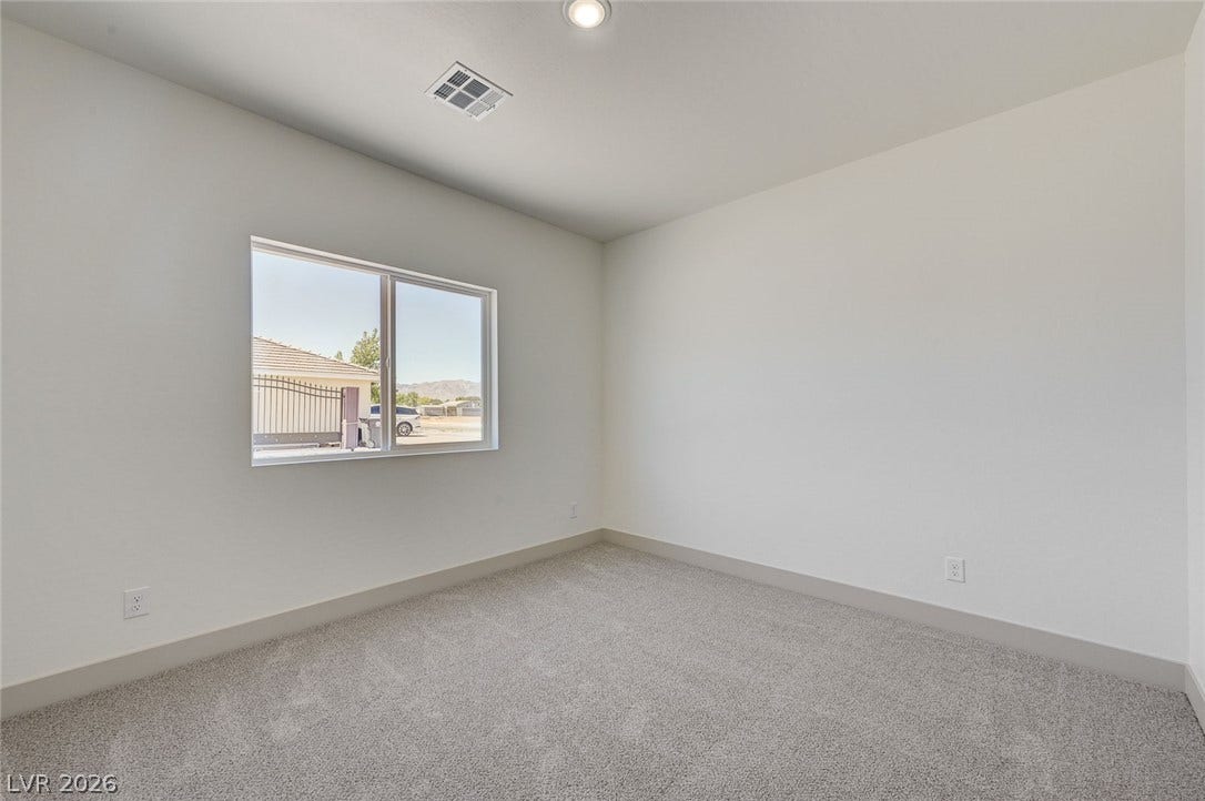Plush carpeting and a wide window bring warmth to this versatile secondary bedroom.