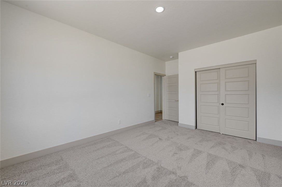 Plush carpeting and clean lines define this versatile bedroom space.