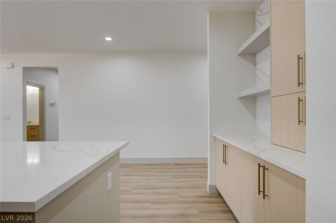 Gleaming stone countertops and modern cabinetry highlight this open-concept kitchen space.