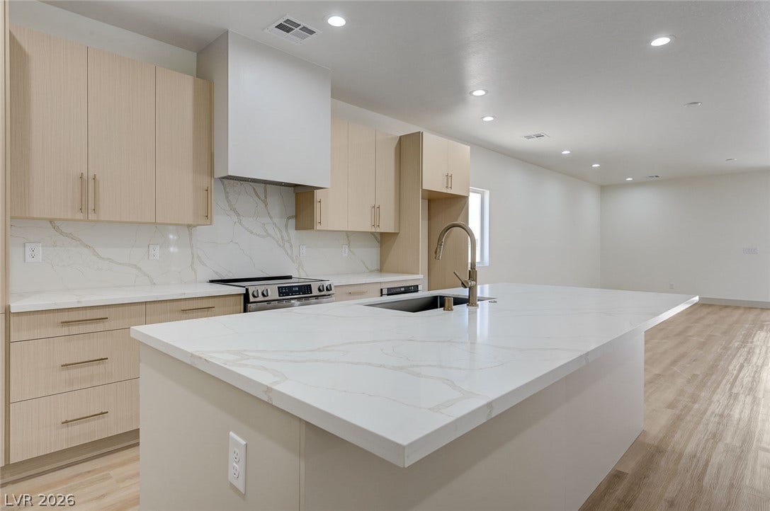 A spacious central island with quartz countertops anchors this contemporary open-concept kitchen.