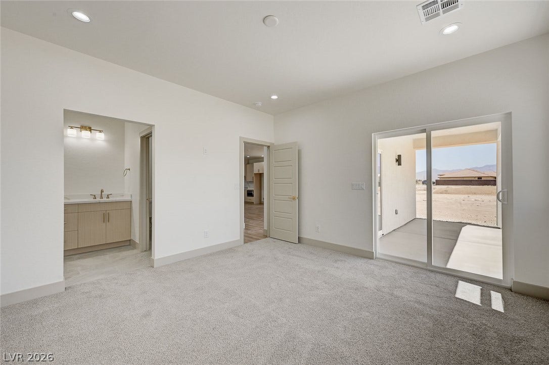 Sliding glass doors connect this carpeted suite directly to a covered outdoor patio.