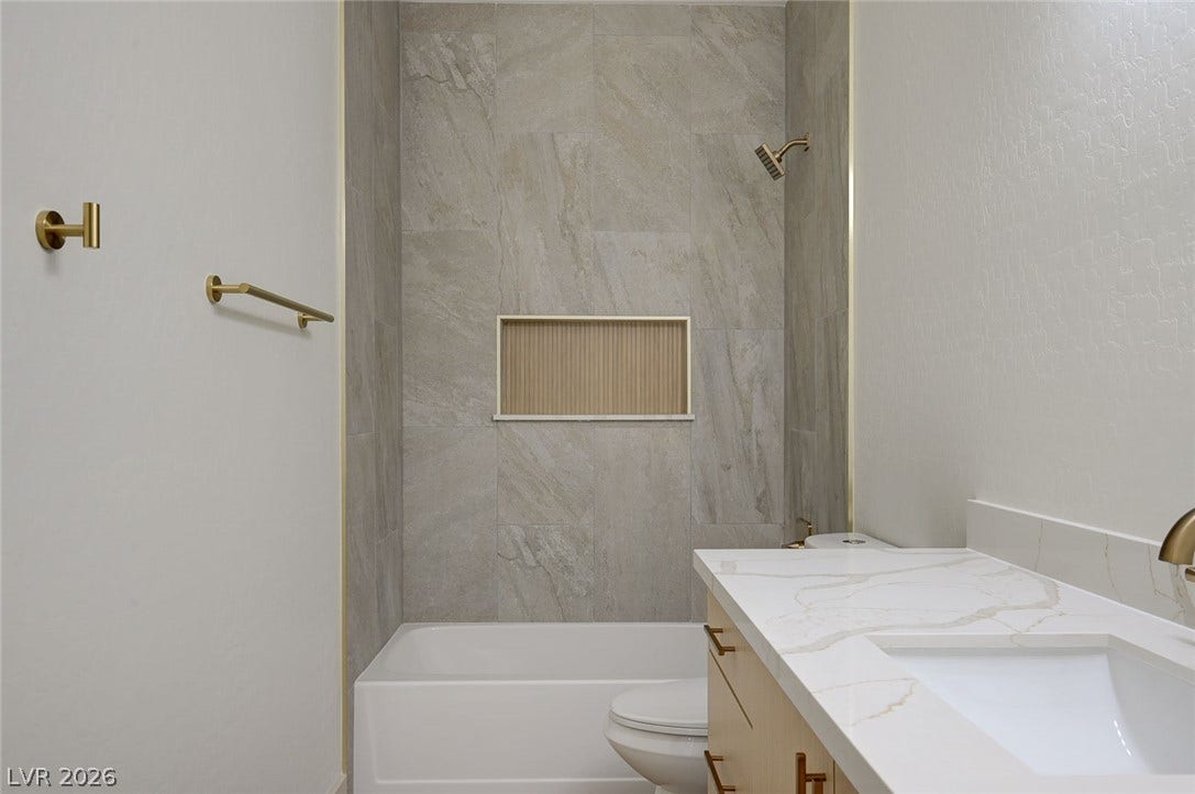 Fine stone tile and modern fixtures elevate this sleek bathroom design.
