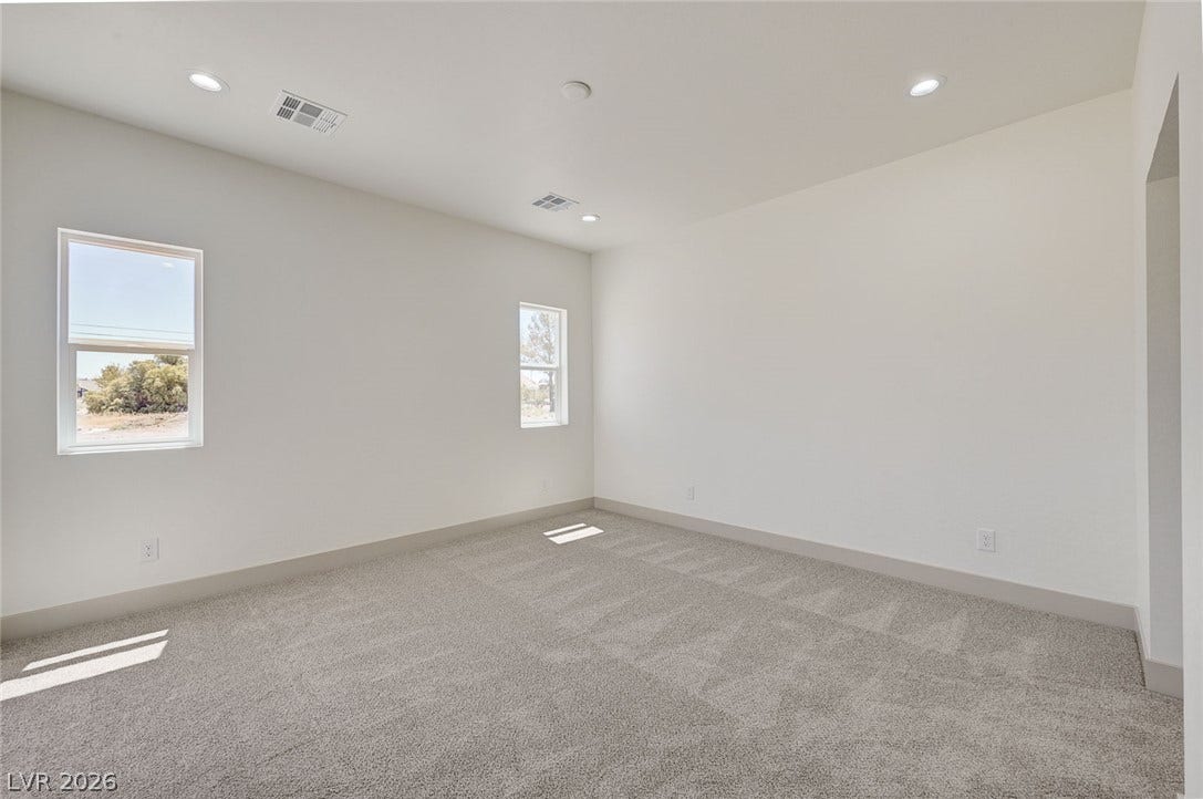 Recessed lighting and soft carpeting create a comfortable atmosphere in this versatile space.