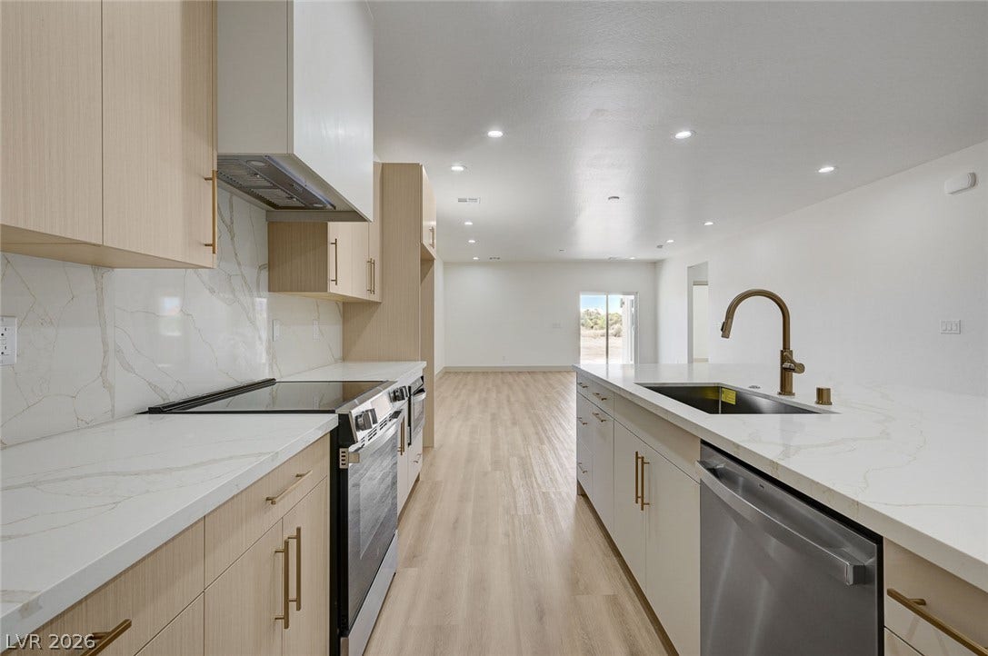 Gleaming stone countertops and modern cabinetry highlight this open-concept kitchen.