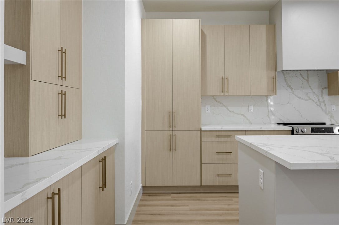 Sleek modern cabinetry paired with marble-veined quartz countertops defines this gourmet kitchen space.