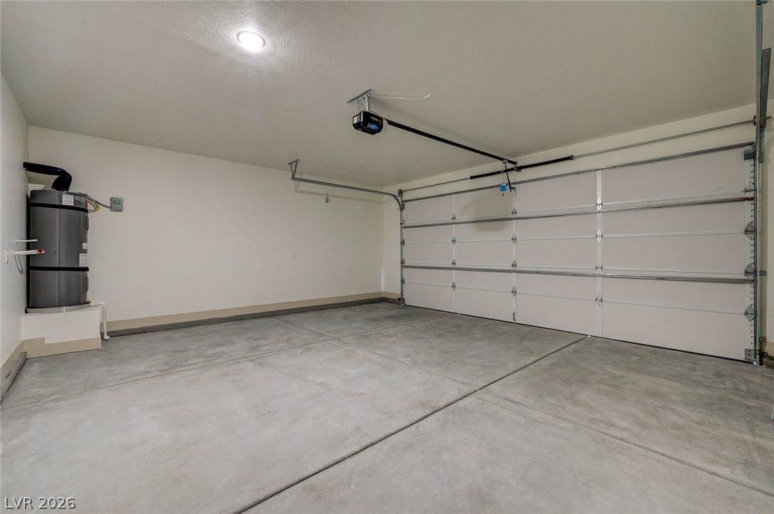 An attached two-car garage features durable concrete flooring and an automatic overhead door opener.