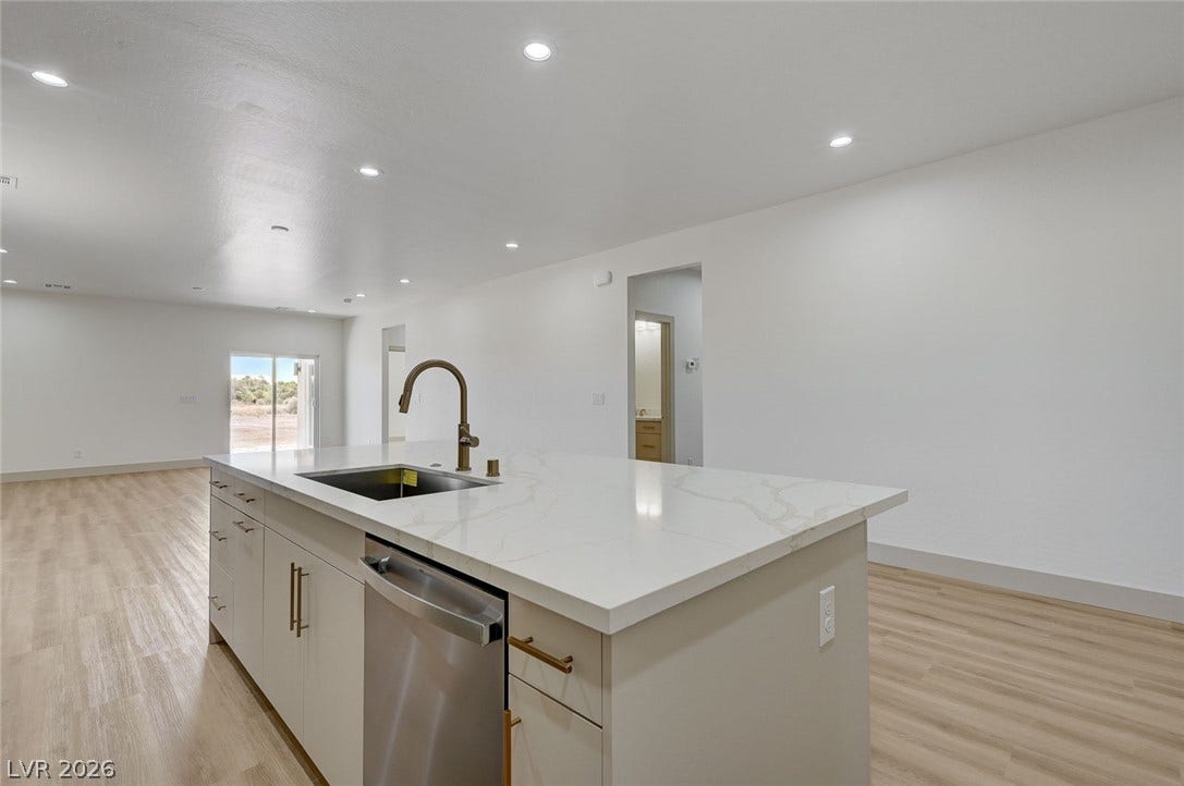 An expansive open floorplan flows seamlessly from the modern island kitchen into the living spaces.
