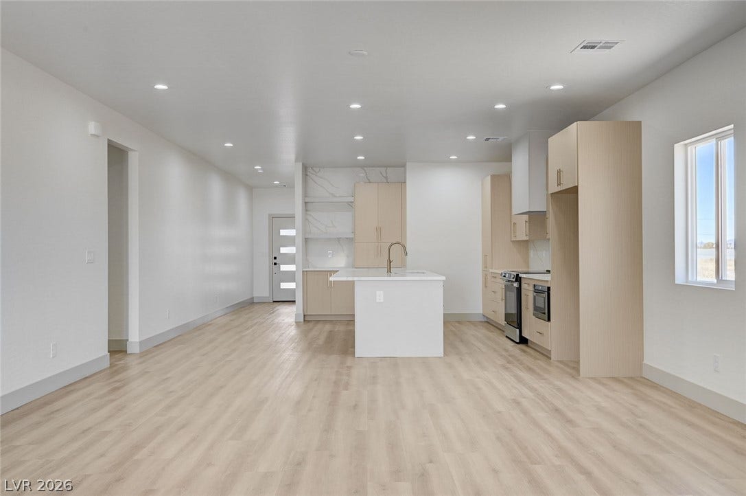 An open-concept layout connects the airy living area directly to a contemporary kitchen.