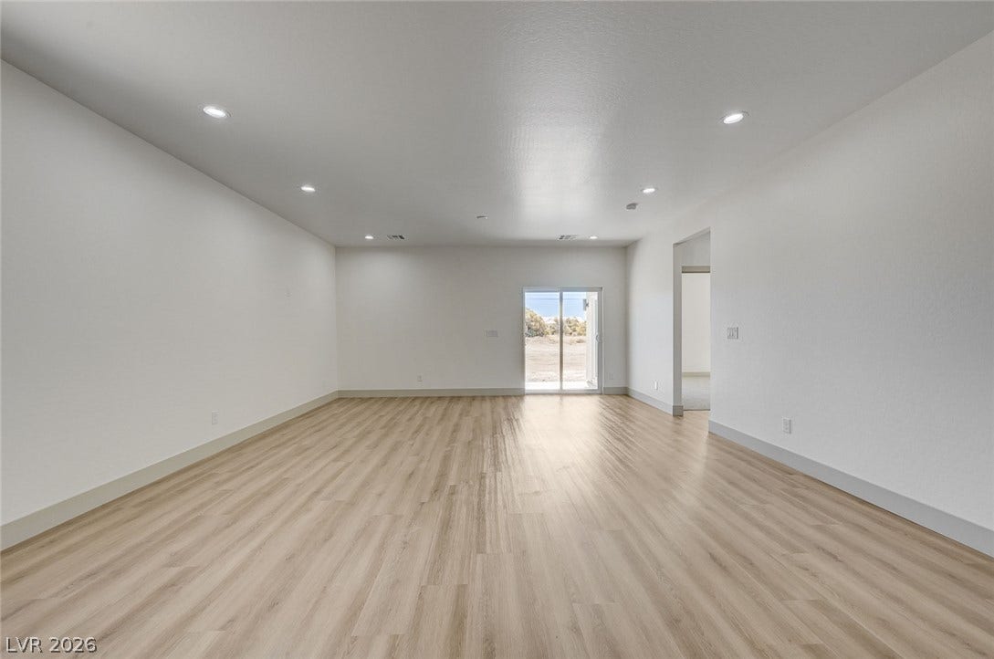 Recessed lighting and wood-inspired flooring highlight this airy, open-concept living space.