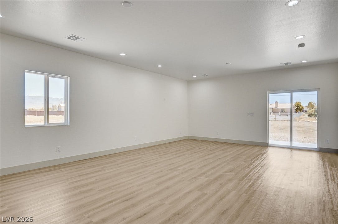 Recessed lighting illuminates this versatile interior space detailed with clean walls and smooth flooring.