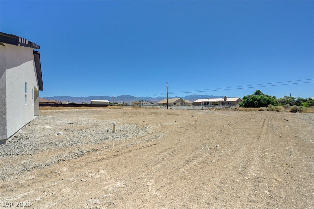 An open desert lot offers mountain views under a clear blue sky.