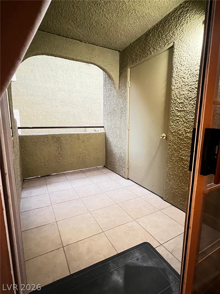7950 W Flamingo Road, #1128, Las Vegas, NV 89147 Tiled flooring and stucco finishes define this private outdoor balcony retreat.