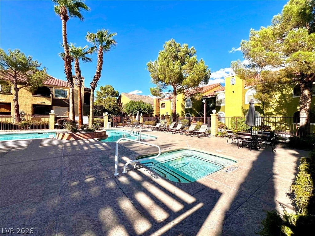 7950 W Flamingo Road, #1128, Las Vegas, NV 89147 An inviting community spa and swimming pool area is surrounded by palm trees and lounging spots.