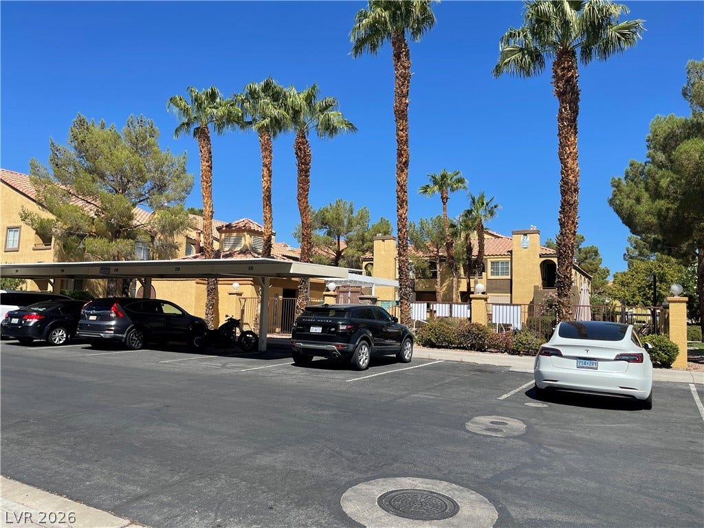 7950 W Flamingo Road, #1128, Las Vegas, NV 89147 Covered parking bays and towering palm trees frame this desert-style residential complex.