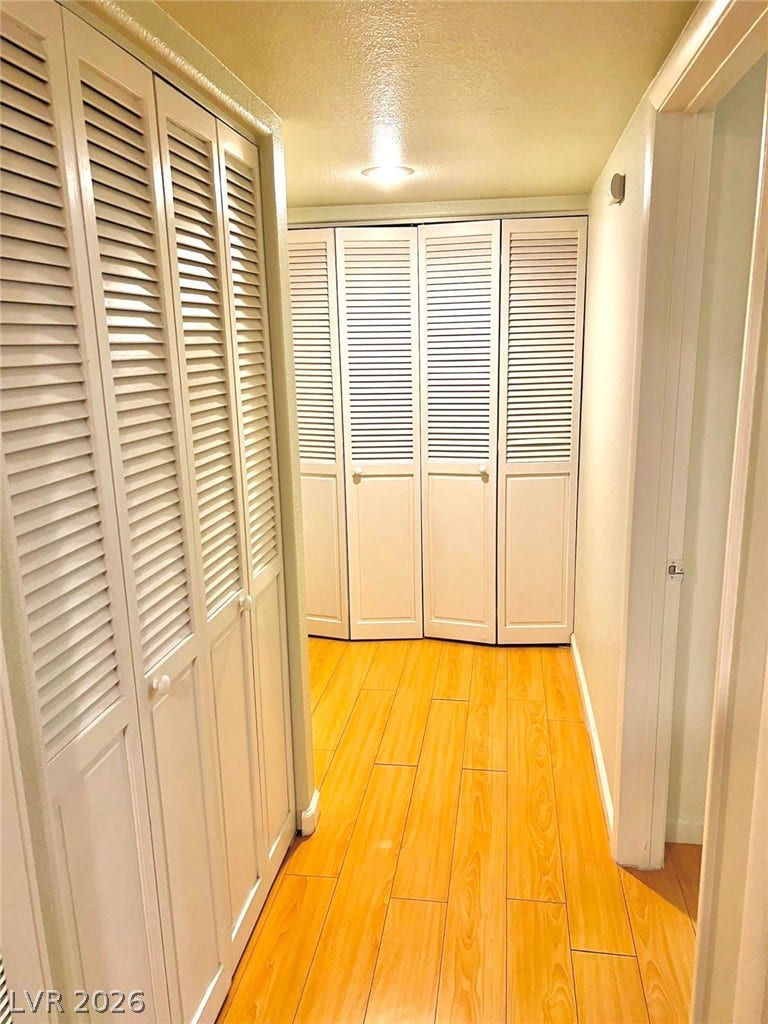 7950 W Flamingo Road, #1128, Las Vegas, NV 89147 Louvered doors line this functional hallway featuring wood-plank flooring.