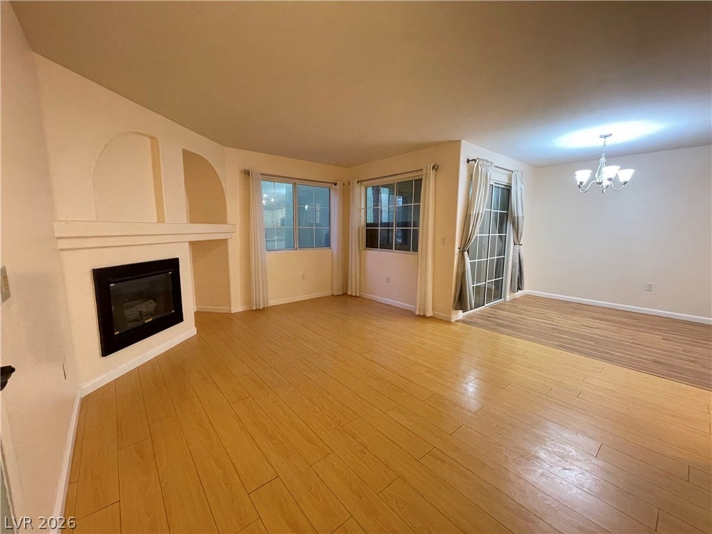 7950 W Flamingo Road, #1128, Las Vegas, NV 89147 Smooth wood floors flow past a cozy fireplace in this comfortable open living area.