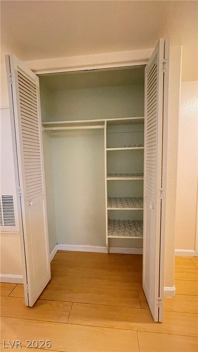 7950 W Flamingo Road, #1128, Las Vegas, NV 89147 Louvered doors open to reveal structured closet storage set over warm wood-style flooring.