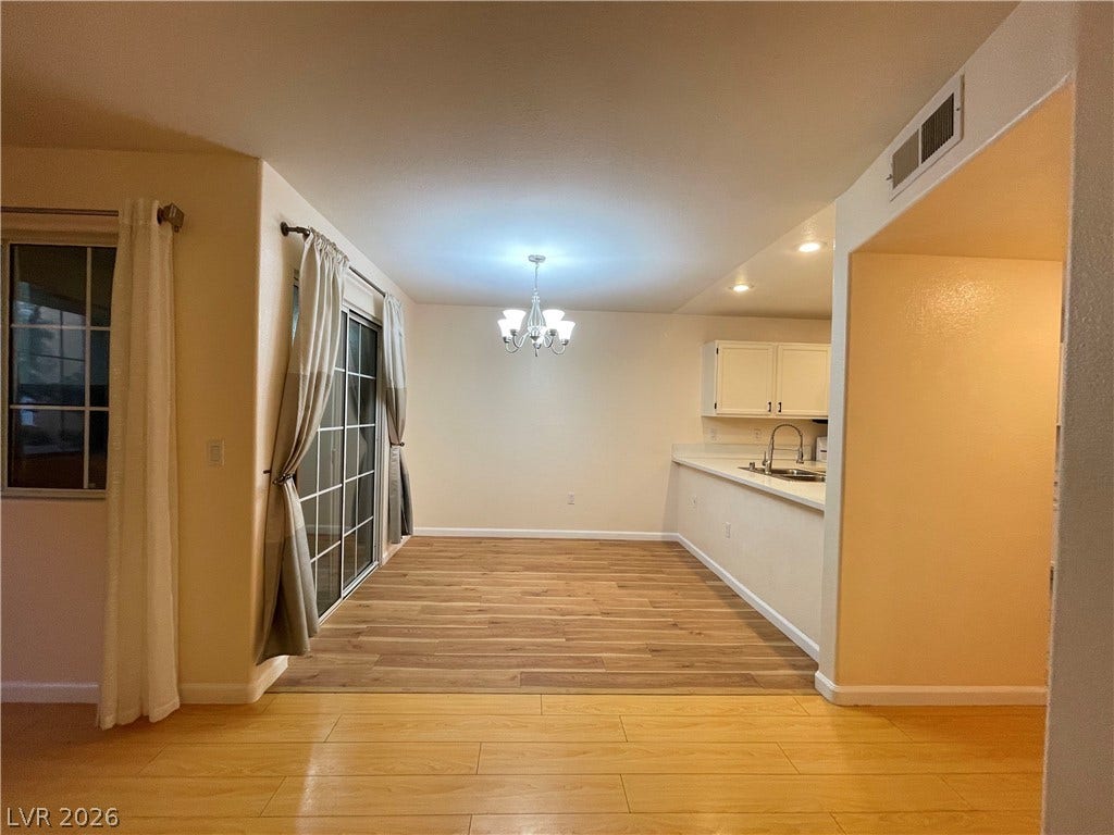 7950 W Flamingo Road, #1128, Las Vegas, NV 89147 Gleaming wood floors connect the open dining space to the adjacent kitchen area.