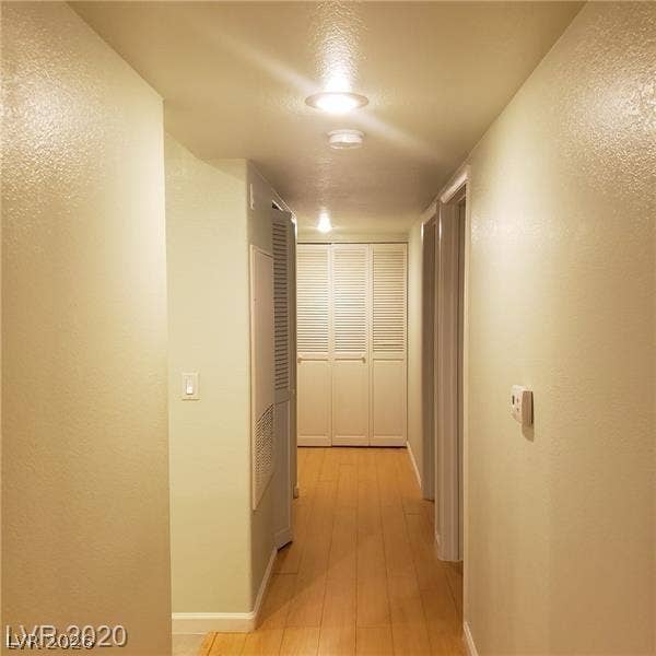 7950 W Flamingo Road, #1128, Las Vegas, NV 89147 Smooth wood flooring guides the way down a light-filled corridor toward integrated storage closets.