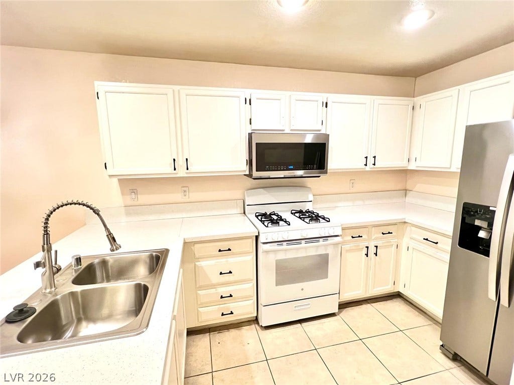 7950 W Flamingo Road, #1128, Las Vegas, NV 89147 Bright white cabinetry complements the expansive countertops and functional layout in this tiled kitchen.