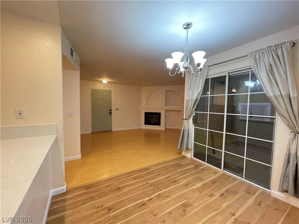 7950 W Flamingo Road, #1128, Las Vegas, NV 89147 Polished wood floors lead from the dining space into the fireplace-warmed living room.