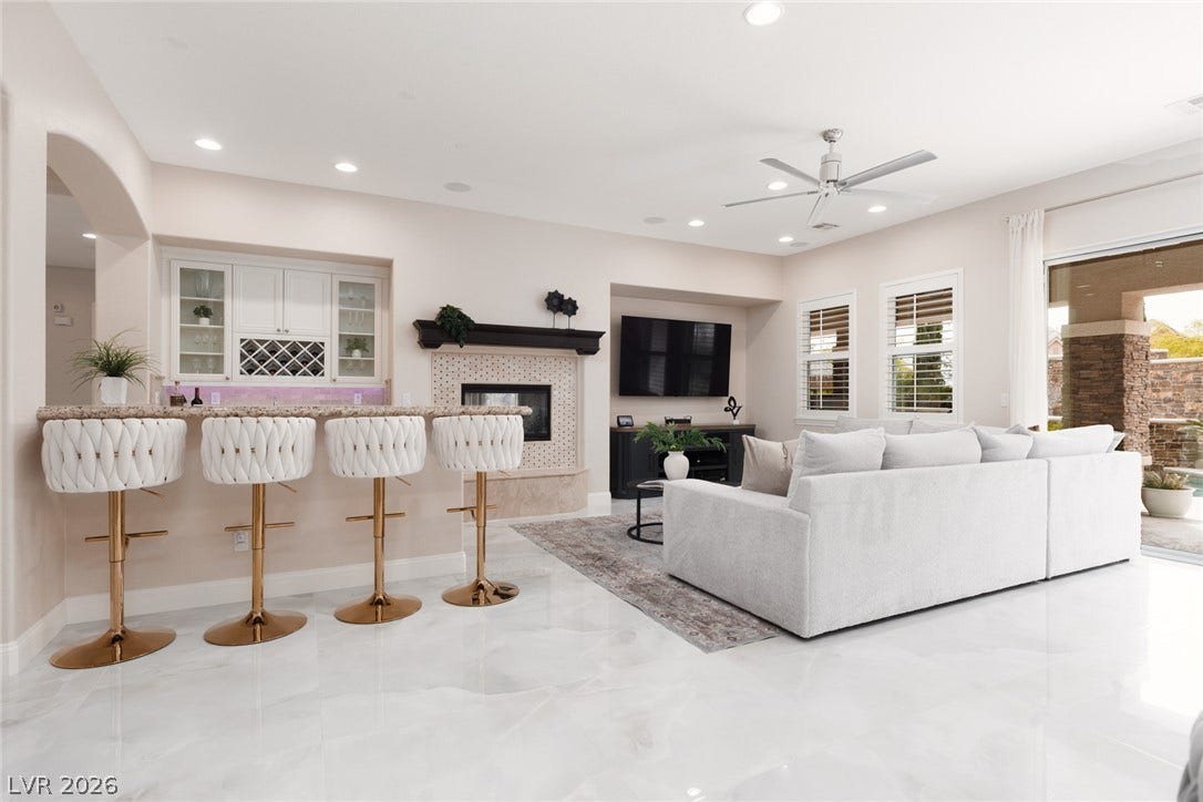 9795 Amador Ranch Avenue, Las Vegas, NV 89149 Polished stone flooring runs throughout this airy living room complete with a built-in wet bar.
