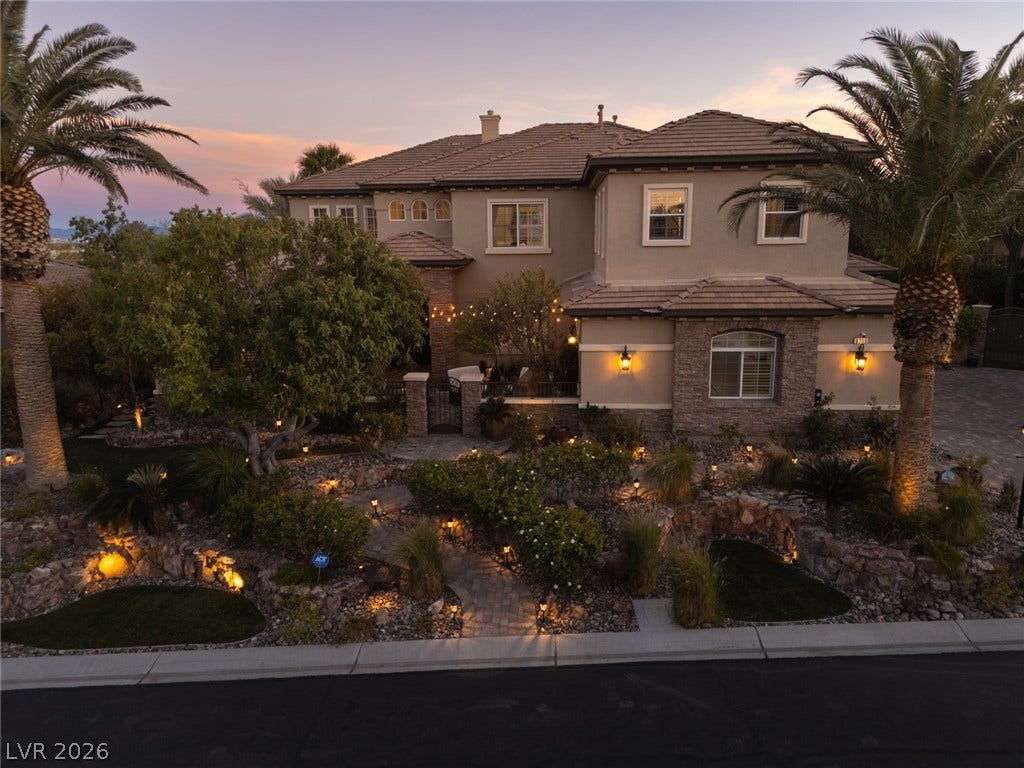 9795 Amador Ranch Avenue, Las Vegas, NV 89149 Lush desert landscaping and elegant stone accents enhance the curb appeal of this two-story residence.