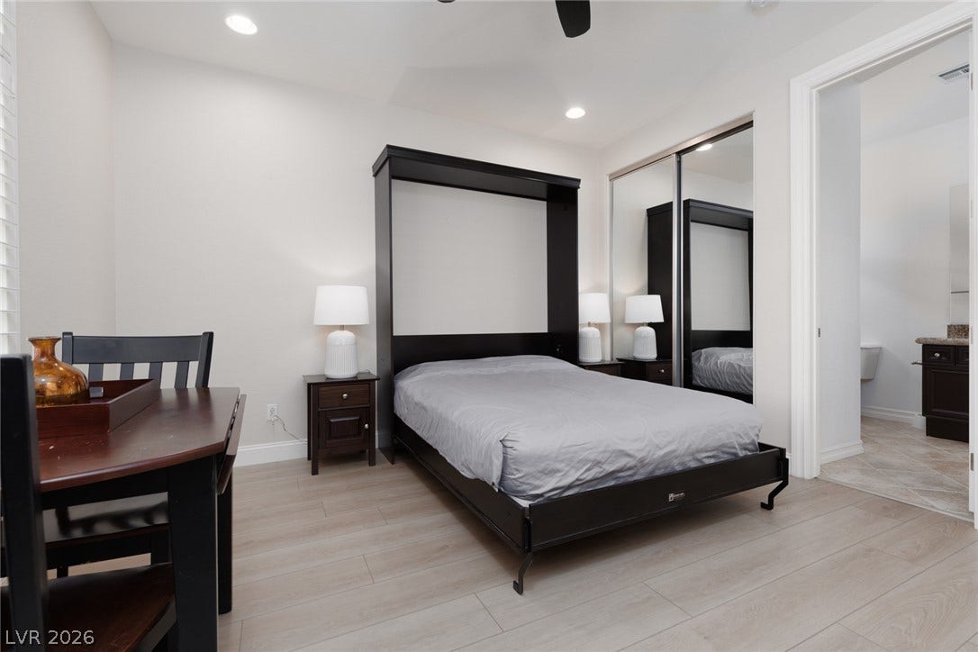 9795 Amador Ranch Avenue, Las Vegas, NV 89149 Recessed lighting and wood-inspired flooring elevate this versatile bedroom with mirrored closets.
