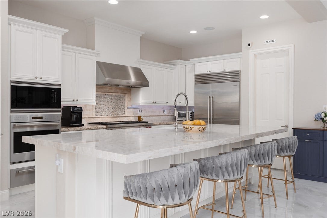 9795 Amador Ranch Avenue, Las Vegas, NV 89149 Gleaming stone countertops and stainless appliances anchor this beautifully designed culinary space.
