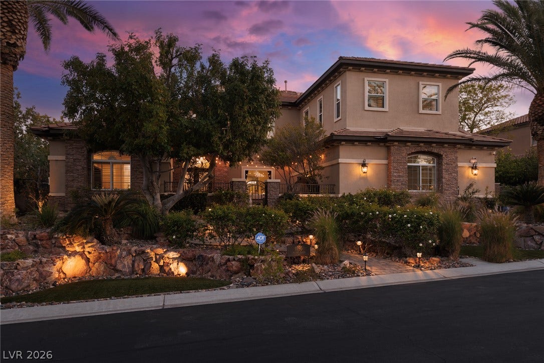 9795 Amador Ranch Avenue, Las Vegas, NV 89149 Lush landscaping and stone accents frame this elegant two-story residence at dusk.
