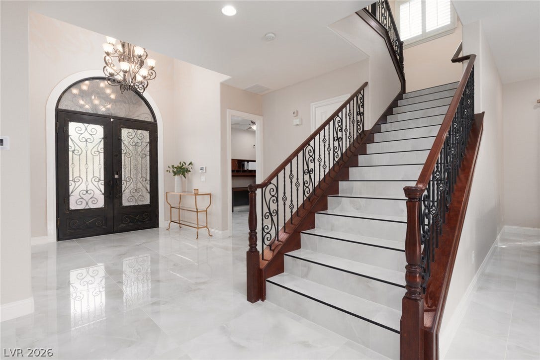 9795 Amador Ranch Avenue, Las Vegas, NV 89149 Polished tile flooring and an elegant wrought-iron staircase greet guests in this grand entryway.