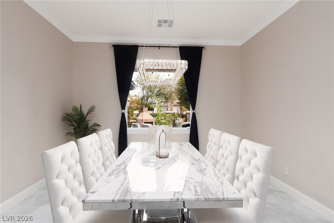 9795 Amador Ranch Avenue, Las Vegas, NV 89149 Crown molding and large windows elevate this formal dining space.
