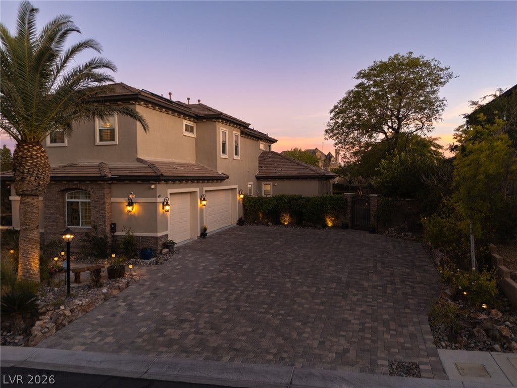 9795 Amador Ranch Avenue, Las Vegas, NV 89149 A spacious paver driveway leads to the multi-car garage of this elegant two-story residence.