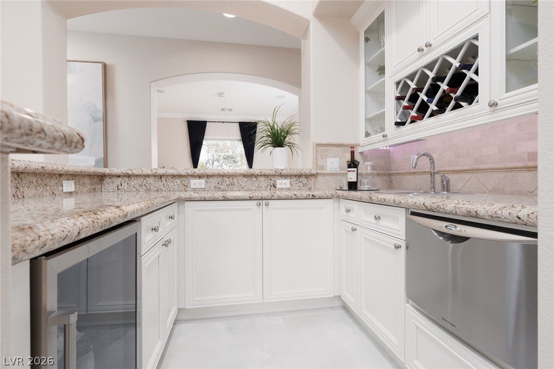 9795 Amador Ranch Avenue, Las Vegas, NV 89149 Polished stone countertops and custom cabinetry define this elegant built-in wet bar setup.