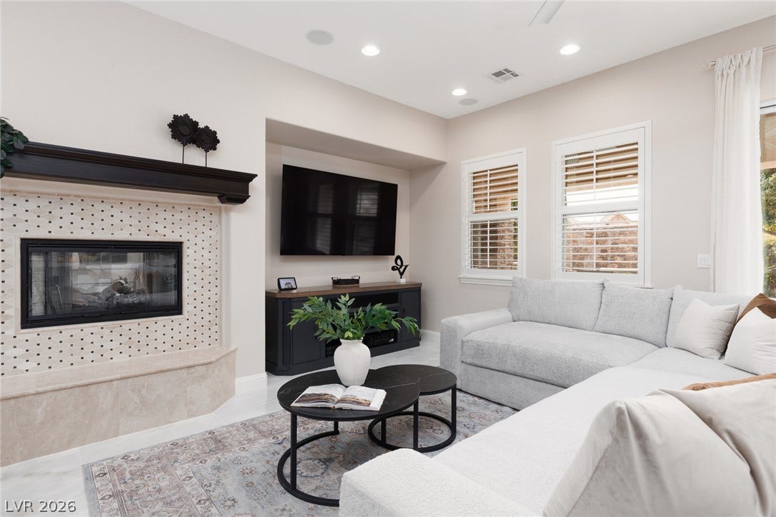 9795 Amador Ranch Avenue, Las Vegas, NV 89149 An elegant fireplace with tiled surround highlights this inviting living space featuring plantation shutters.